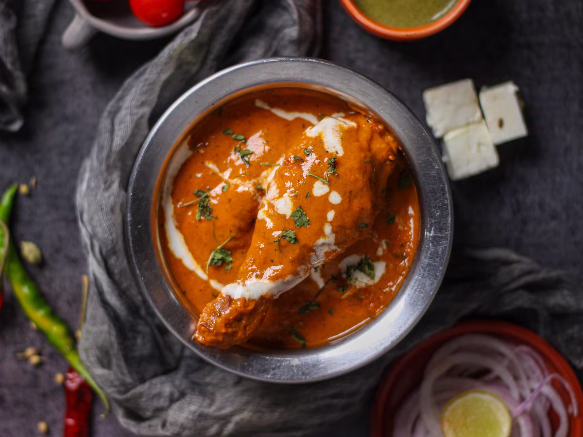 Butter chicken v kovové misce se smetanovou spirálou, fotografie, avif