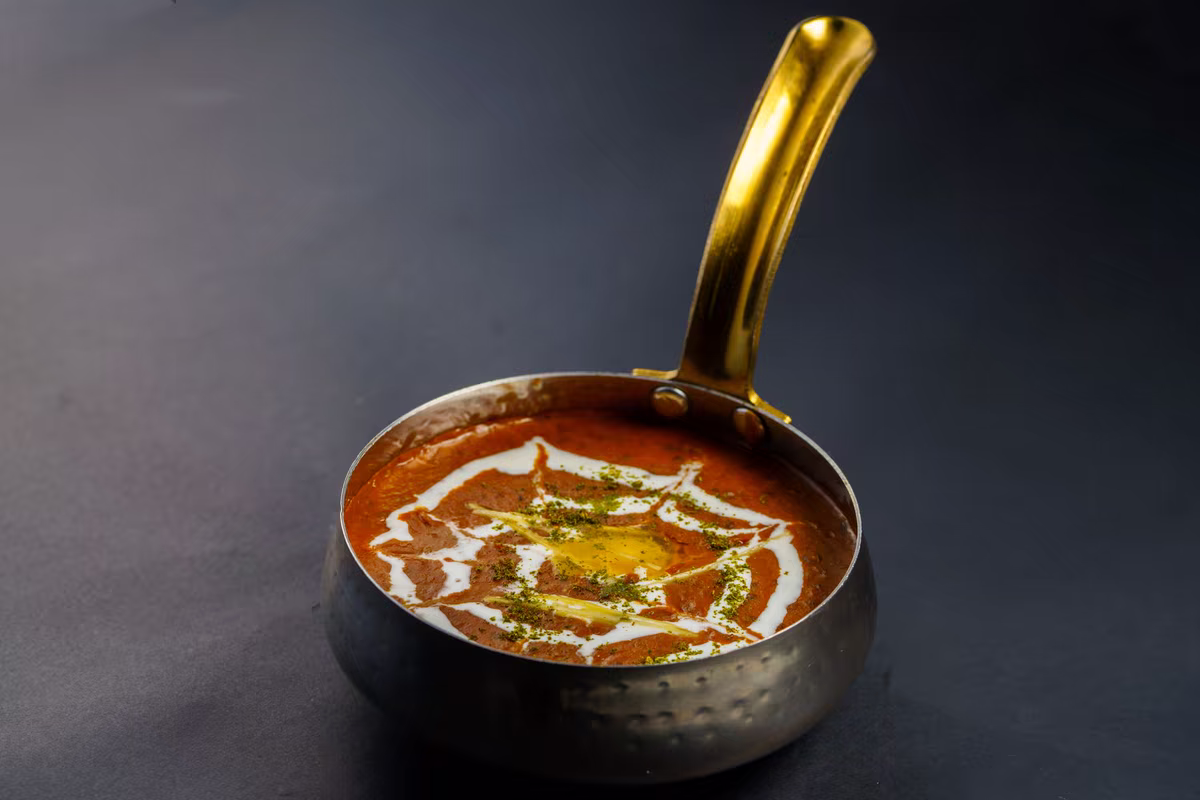 Dal makhani v tmavé pánvi na šedém pozadí, fotografie, avif