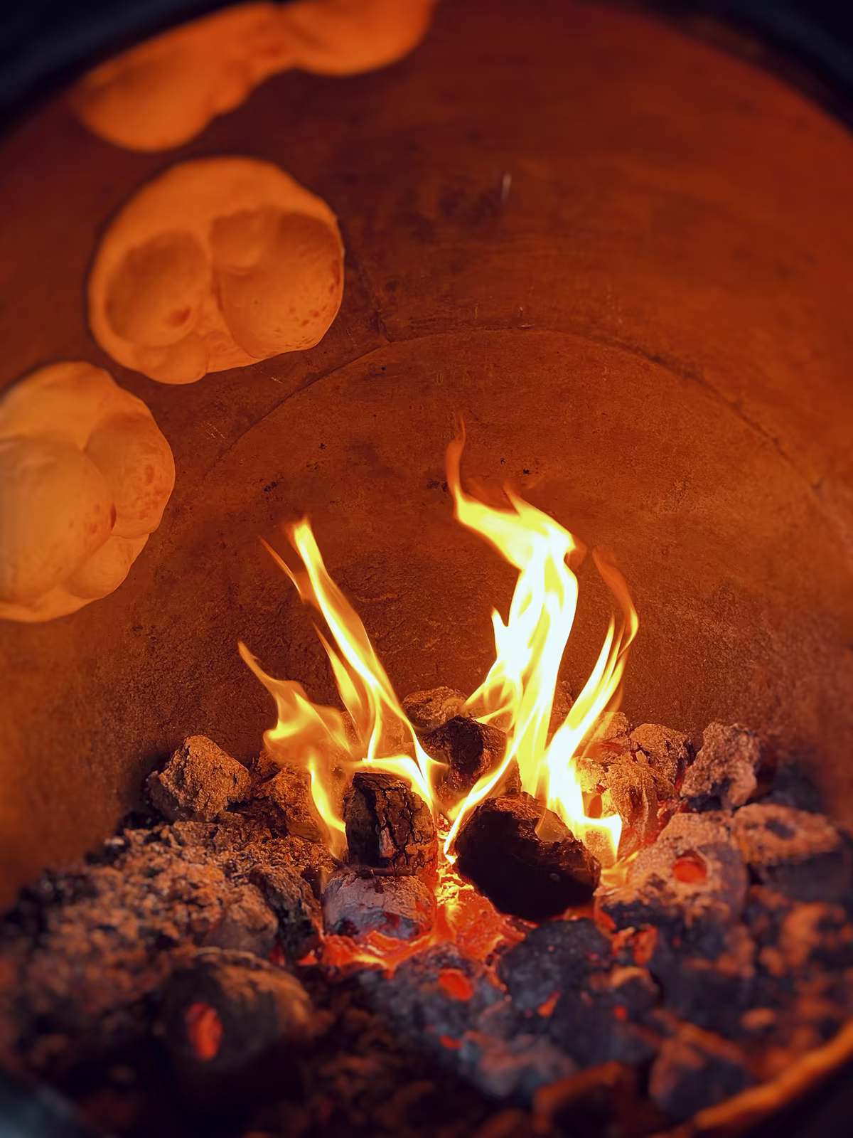 Plameny a placky na stěně hliněné pece tandoor, fotografie, avif